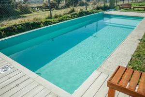 a swimming pool with a bench and blue water at Domo 4 - Domos Aiken Chapa Glamping en Zona Cruz del Sur Chapadmalal para 2 PAX - Hola Sur in Mar del Plata