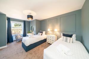une chambre avec deux lits et une chaise et une fenêtre dans l'établissement Caddie's Cottage on Eden View Estate, à St Andrews
