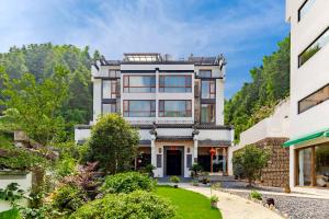 una vista esterna di una casa con montagne sullo sfondo di 问安民宿（黄山风景区店） a Mount Huangshan
