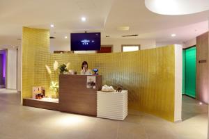 a woman standing at a counter in a lobby at Hotel Mirasole International in Gaeta
