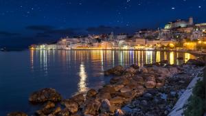 a city at night with lights on the water at Hotel Mirasole International in Gaeta