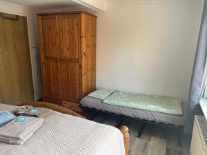 a room with two beds and a wooden cabinet at Ferienhaus Ankerplatz in Lambrechtshagen