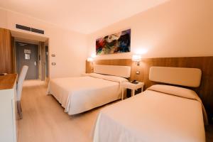 a hotel room with two beds and a painting on the wall at Hotel Mirasole International in Gaeta