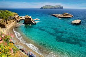a view of a beach with rocks and the ocean at Hotel Mirasole International in Gaeta