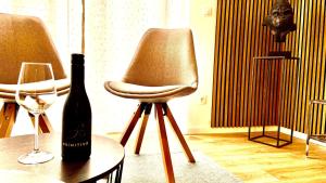 a bottle of wine sitting on a table next to a chair at Better Living-Exklusive Ferienwohnung 76qmTerrasse in Montabaur +15 photos