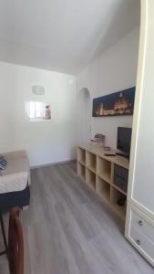a room with a bed and a desk with a television at CA del CARMINE in Florence