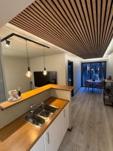 a kitchen with a sink and a living room with a table at Leilighet i Fredrikstad in Fredrikstad