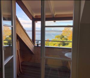 a room with a view of the ocean through a window at Seeblick - Chice Maisonette über den Dächern von Meersburg in Meersburg