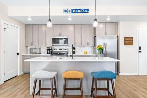 a kitchen with a large white island with two stools at PonDerosa Place condo in St. George +38 photos