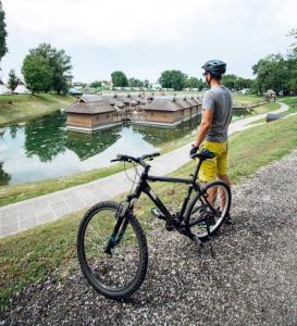 a man is standing next to a bike at Central Brežice Chalet & Parking in Brežice