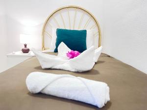 ein Bett mit weißen Kissen und einer rosa Blume darauf in der Unterkunft ☆The Peaceful Valencia Homestay☆ w/ Terrace⌘Parking⌘BBQ in Valencia