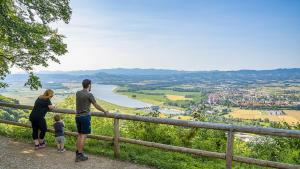 a family standing on a fence looking at a river at Central Brežice Chalet & Parking in Brežice