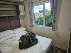 a bag sitting on a bed in a room with a window at Beachside Holiday Park in Brean