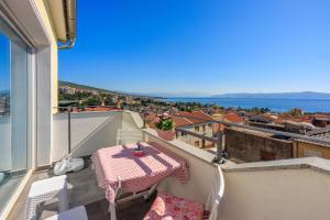einen Balkon mit einem Tisch und Stadtblick in der Unterkunft Filip in Crikvenica