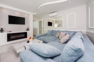 ein Wohnzimmer mit einer blauen Couch und einem Fernseher in der Unterkunft Filip in Crikvenica