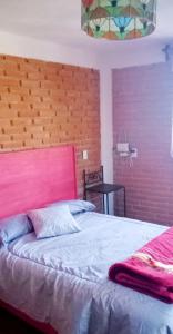 Un dormitorio con una cama grande con cabecero rojo. en Finca de los Leones - Cabaña Primavera, en Pachuca de Soto