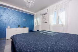 ein blaues Schlafzimmer mit einem Bett und einem Kronleuchter in der Unterkunft Filip in Crikvenica