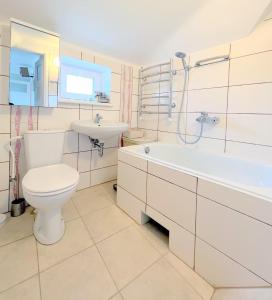 een badkamer met toilet, wastafel en bad bij Vintage 70 Villa in Šiauliai