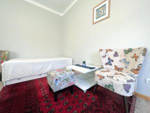 een slaapkamer met een bed, een stoel en een tafel bij Vintage 70 Villa in Šiauliai