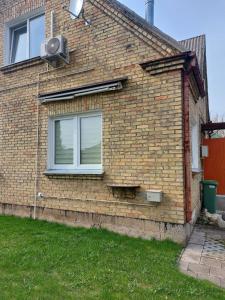 een bakstenen huis met een raam en een luidspreker bij Vintage 70 Villa in Šiauliai