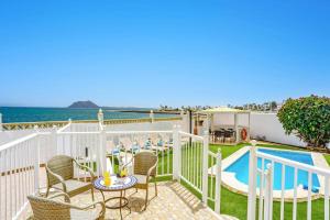 balkon ze stołem i krzesłami oraz basen w obiekcie Villa Magali Mar by Villa Plus w Corralejo