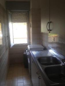 a small kitchen with a sink and a window at Le Zagare apartments in SantʼAlessio Siculo +73 photos