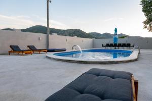 a pool with two chairs and a couch in a patio at Vila za odmor Svitavac in Trebinje