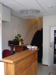 a room with a desk and a staircase with a chandelier at Hotel Keistad in Amersfoort