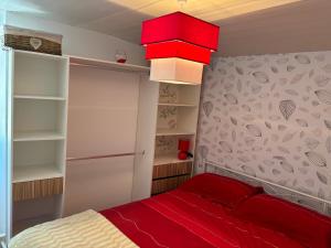 a small bedroom with a red bed and shelves at Carballo Alenza,2 in Castro Caldelas