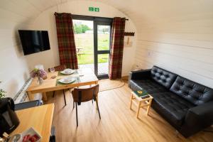 a living room with a black couch and a table at Ben Nevis Pod in Fort William