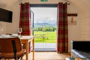 a living room with a table and a window at Ben Nevis Pod in Fort William