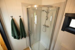 a shower in a bathroom with green towels at Ben Nevis Pod in Fort William +18 photos