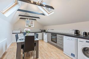 a kitchen with a table and a washer and dryer at Redhill Hideaway Stylish Spacious Apartment in Redhill