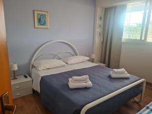 ein Schlafzimmer mit einem Bett, auf dem zwei Handtücher liegen in der Unterkunft Terrazza Fiumara in Letojanni