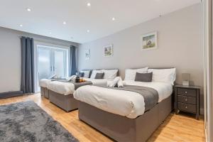 two beds in a bedroom with a window at Redhill Hideaway Stylish Spacious Apartment in Redhill
