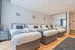 three beds in a room with a mirror at Redhill Hideaway Stylish Spacious Apartment in Redhill