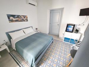 Un dormitorio con una cama y un televisor. en Rosa Dei Venti Guest House, en Cabras