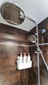 a bathroom with a shower with a mirror and four toiletries at BEACH VALENCIA LUXURY E-Arenas 117 Apartment with terrace in Edificio Arenas in Valencia +22 photos