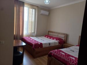 due letti in una piccola stanza con una finestra di Mate's GUEST HOUSE a Kobuleti