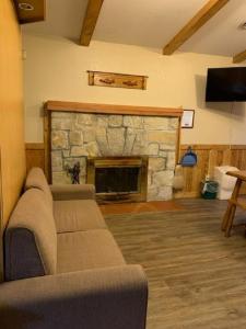 a living room with a couch and a stone fireplace at Montauk Lodge in Jadwin