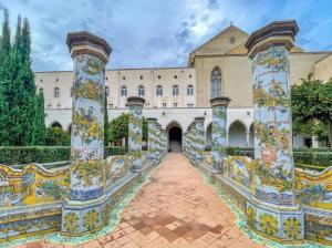 a courtyard of a building with mosaics on columns at Suite SAN GENNARO in Naples