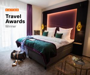 a hotel room with a large bed and a sign that says travel awards at ONNO Boutique Hotel & Apartments in Rendsburg