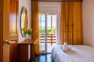 - une chambre avec un lit et une porte avec un balcon dans l'établissement Espacio de paz, ideal para familias Villa Amalia, à Llacuna 48 autres photos