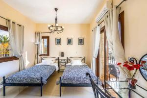 une chambre avec deux lits et une table en verre dans l'établissement Petrides Villa, à Argaka 30 autres photos