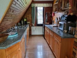 a large kitchen with wooden cabinets and a staircase at Ferienhaus Falknerei am Rennsteig in Winterstein +6 photos