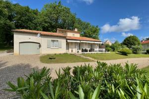 a house with a garage on a gravel driveway at La Terrasse in Douzillac