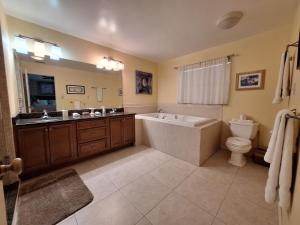 a bathroom with a tub and a toilet and a sink at 3 Bed 2 Bath Amazing Lakeview , Jacuzzi Bath Tub in Oviedo +16 photos