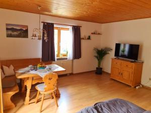 a living room with a table and a tv at Ruhige Ferienwohnung in Bad Tölz in Bad Tölz