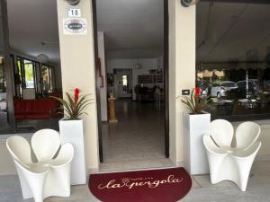 ein Geschäft mit weißen Stühlen vor einem Spiegel in der Unterkunft Hotel La Pergola in Bellaria-Igea Marina