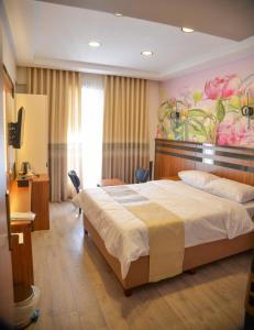 a bedroom with a bed and a painting on the wall at Vizyon Life Pansiyon in Elazığ